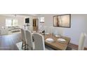 Bright dining area with wood floors, a large window, and an open view into the adjacent living room at 22420 N 20Th Pl, Phoenix, AZ 85024