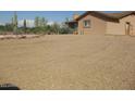 Tan single-story home features gravel landscaping with desert plants at 27239 N 64Th Way, Scottsdale, AZ 85266