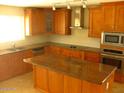 Spacious kitchen features custom wood cabinets, granite countertops, and stainless steel appliances at 27239 N 64Th Way, Scottsdale, AZ 85266