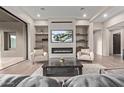 Modern living room with fireplace, built-in shelves, and comfortable seating arrangement at 31226 N Granite Reef Rd, Scottsdale, AZ 85266