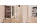 Entryway features a wood front door, neutral walls, and tile flooring, flowing seamlessly into the home's interior at 3540 E Dolphin Ave, Mesa, AZ 85204