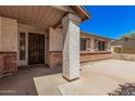 Inviting front porch with brick accents, decorative security door, and textured stucco, offering a welcoming entrance to the home at 3540 E Dolphin Ave, Mesa, AZ 85204