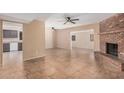 Spacious living room with a cozy brick fireplace, tile flooring, and an open layout with multiple ceiling fans at 3540 E Dolphin Ave, Mesa, AZ 85204