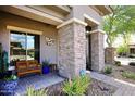 Close-up of a charming front porch with textured stone pillars and desert-style greenery at 35707 N 34Th Ln, Phoenix, AZ 85086