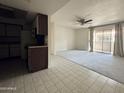 Bright living room featuring neutral carpet, a sliding glass door, and a ceiling fan at 4444 E Paradise Village N Pkwy # 251, Phoenix, AZ 85032