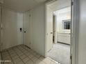 Entryway with tiled floor, closet, and view into bathroom featuring vanity and mirror at 4444 E Paradise Village N Pkwy # 252, Phoenix, AZ 85032