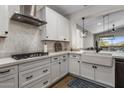 Modern kitchen featuring sleek white cabinets, stylish backsplash, and stainless steel appliances at 537 E Balao Dr, Phoenix, AZ 85085