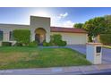 Inviting front yard with lush green lawn, mature shrubs, and a charming terracotta tile roof at 5718 N 72Nd Pl, Scottsdale, AZ 85250