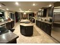Open kitchen boasts expansive countertops, dark cabinets and stainless steel appliances, perfect for cooking and entertaining at 5751 E Ludlow Dr, Scottsdale, AZ 85254