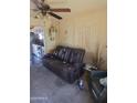 Inviting living room featuring a comfortable leather sofa and a ceiling fan at 735 E Vaughn Dr, Tempe, AZ 85283
