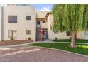 Exterior view of the condo building with red stairs, a tree, and a charming courtyard at 750 E Northern Ave # 1089, Phoenix, AZ 85020