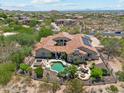 Aerial view of a backyard with a swimming pool, spa, outdoor kitchen, fire pit, and desert landscaping at 8540 E Mcdowell Rd # 10, Mesa, AZ 85207