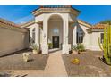 Inviting front entrance with stone walkway, desert landscaping and arched entryway at 8540 E Mcdowell Rd # 10, Mesa, AZ 85207
