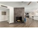 Lovely tiled fireplace with hardwood floors leading to the living and kitchen areas at 8714 E Mackenzie Dr, Scottsdale, AZ 85251