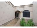 Covered entrance with arched entryway, neutral color scheme, and desert landscaping at 8941 E Maple Dr, Scottsdale, AZ 85255