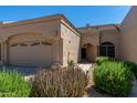 View of single-story beige home with desert landscaping, three-car garage and stylish architecture at 8941 E Maple Dr, Scottsdale, AZ 85255
