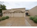 Single-story beige home with three-car garage, desert landscaping and a neutral color palette at 8941 E Maple Dr, Scottsdale, AZ 85255