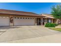 Home exterior featuring a wide driveway and lush, green yard at 11360 E Keats Ave # 70, Mesa, AZ 85209