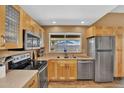 A bright kitchen with stainless steel appliances, light wood cabinets, and a window overlooking the backyard at 12447 N 50Th Ln, Glendale, AZ 85304