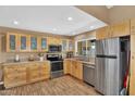 Bright kitchen featuring stainless steel appliances, light wood cabinets, and tile flooring at 12447 N 50Th Ln, Glendale, AZ 85304