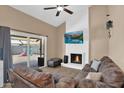 Cozy living room showcasing a brick fireplace, ceiling fan, and sliding glass door to the backyard at 12447 N 50Th Ln, Glendale, AZ 85304