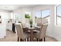 Bright dining area featuring large windows, wood-look floors, and modern finishes at 12506 W Corrine Dr, El Mirage, AZ 85335