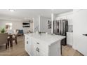 Open concept kitchen island with stainless steel refrigerator adjacent to the living room at 12506 W Corrine Dr, El Mirage, AZ 85335