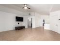 Spacious living room featuring tile flooring, ceiling fan, and a large wall for entertainment center at 13145 W Cambridge Ave, Goodyear, AZ 85395