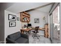 Home office featuring built-in shelving, a comfortable seating area, and a sliding glass door providing natural light at 14002 N 49Th Ave # 1040, Glendale, AZ 85306