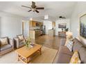 Open-concept living room features a ceiling fan, hardwood floors, and updated kitchen at 1440 N Idaho Rd # 1048, Apache Junction, AZ 85119