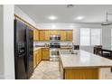 Well-lit kitchen featuring stainless steel appliances, wooden cabinets, and a tile backsplash at 15339 W Jefferson St, Goodyear, AZ 85338