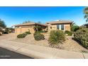 Well-manicured desert landscaping complements this charming single-story home, with a wide sidewalk at 19714 N Rim Dr, Surprise, AZ 85374