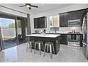 Modern kitchen featuring dark cabinets, stainless steel appliances, a center island, and sliding glass doors at 20638 N 11Th St, Phoenix, AZ 85024