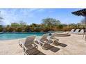 Luxurious pool and spa area with poolside lounge chairs surrounded by lush landscaping and blue skies at 2304 N Steele Cir, Mesa, AZ 85207