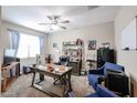 A dedicated home office features a ceiling fan, a large desk and a comfortable chair at 30213 W Fairmount Ave, Buckeye, AZ 85396