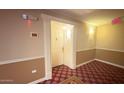 Hallway featuring unit 228 shows carpeted floors, tan walls and a white door with ornate trimming at 4200 N Miller Rd # 228, Scottsdale, AZ 85251