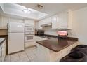 Cozy kitchen with white cabinetry, a breakfast bar, and modern appliances offers functional charm at 4200 N Miller Rd # 228, Scottsdale, AZ 85251