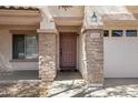 Close-up of front entry with stone pillars, address numbers, and wood door at 43232 W Magnolia Rd, Maricopa, AZ 85138