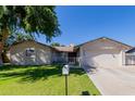 Charming single-story home featuring a well-maintained lawn, mature tree, and a two-car garage at 4716 W Hayward Ave, Glendale, AZ 85301