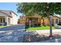 Attractive two-story tan home with a lush lawn, a long driveway, and mature trees providing ample shade at 5323 E Hopi Ave, Mesa, AZ 85206