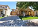 Inviting two-story tan home with a long driveway leading to a spacious garage and manicured front yard at 5323 E Hopi Ave, Mesa, AZ 85206