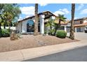 Inviting single-story home with desert landscaping, including a large arched window and stone details at 5406 E Charleston Ave, Scottsdale, AZ 85254
