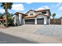 Lovely two-story home boasts a tile roof, three-car garage, and a beautifully paved driveway extension at 5406 E Charleston Ave, Scottsdale, AZ 85254
