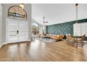 Bright and airy living room with high ceilings, a modern accent wall, and wood-look flooring at 5406 E Charleston Ave, Scottsdale, AZ 85254