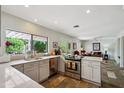 Bright kitchen featuring stone tile flooring, modern stainless steel appliances, and quartz countertops at 5528 E Virginia Ave, Phoenix, AZ 85008