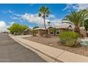 Well maintained home featuring desert landscaping, a two-car garage, and mature palm trees at 6128 E Portia St, Mesa, AZ 85215