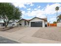 Picture of home with black trim, rock landscaping, and a long driveway at 6228 E Blanche Dr, Scottsdale, AZ 85254