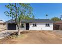 Charming single-story home featuring a well-maintained exterior and a spacious front yard with mature tree at 6733 N 49Th Ave, Glendale, AZ 85301