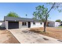 Charming single-story home featuring a well-maintained exterior and a spacious front yard with mature tree at 6733 N 49Th Ave, Glendale, AZ 85301