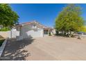 Attractive single-story house featuring a spacious driveway, a two-car garage, and low-maintenance desert landscaping at 7214 W Columbine Dr, Peoria, AZ 85381